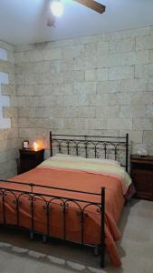 een bed in een slaapkamer met een bakstenen muur bij Casa vacanza Luana torrelapillo Salento in Porto Cesareo