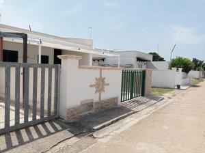 een wit hek voor een wit huis bij Casa vacanza Luana torrelapillo Salento in Porto Cesareo