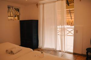 a bedroom with a bed and a large window at Beachfrontguesthouse in Puerto Escondido