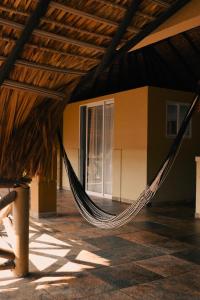 a hammock hanging from a roof in a building at Beach Front Guesthouse in Puerto Escondido