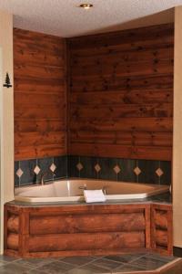 bañera grande en una habitación con paredes de madera en Boarders Inn & Suites by Cobblestone Hotels in Waukon, en Waukon