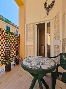 d'une terrasse avec une table et des chaises sur un balcon. dans l'établissement La Suite tra i Musei, à Naples