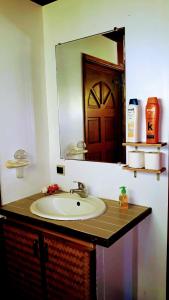 La salle de bains est pourvue d'un lavabo et d'un grand miroir. dans l'établissement Faré blue lagoon, à Moorea