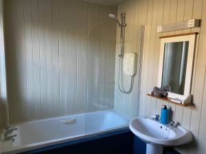 une salle de bain avec une baignoire et un lavabo dans l'établissement Christmas Cottage, à Balmaha 15 autres photos