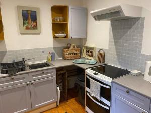 une petite cuisine avec un évier et une cuisinière dans l'établissement Christmas Cottage, à Balmaha