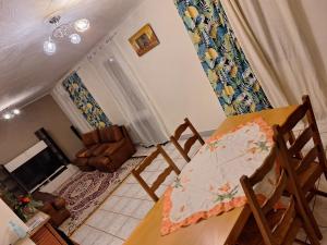 Una habitación con una mesa y sillas y una sala de estar. en L'Arche de Yves-Jody, en Saint-Jean-de-Braye