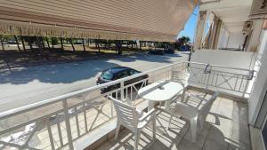 Un balcón con una mesa y sillas y una calle. en KALLIÁNI HOUSE vila kiki, en Flogita