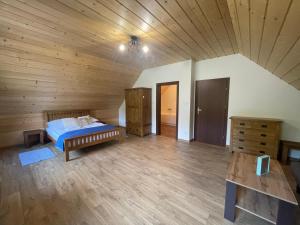 sypialnia z łóżkiem i drewnianym sufitem w obiekcie Smerek 119- Baza Przy Szlaku w Smereku