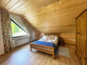 1 dormitorio con cama y techo de madera en Smerek 119- Baza Przy Szlaku en Smerek