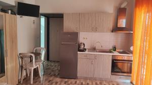 a kitchen with a refrigerator and a table and chairs at KALLIÁNI HOUSE vila kiki in Flogita