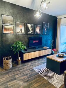 ein Wohnzimmer mit einem TV an einer blauen Wand in der Unterkunft Apartman Viktorija in Žabljak