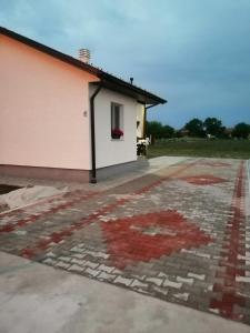 uma casa com um piso de mosaico em frente em Kuća za odmor Jovana&Ivona 2023 OBRADOVIĆ SOKAK 41 em Šimanovci