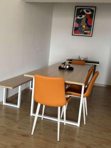 a dining room table with orange chairs and a table at Le VÏU2 in Cotonou