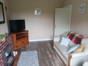 uma sala de estar com um sofá e uma televisão de ecrã plano em The Croft Apartment em Westport