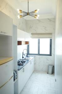 a kitchen with white cabinets and a ceiling at Le VÏU2 in Cotonou