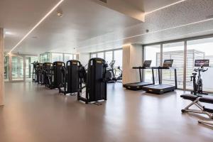 a gym with a row of treadmills and exercise bikes at Bayline- Beachfront and Pool in Armação de Pêra