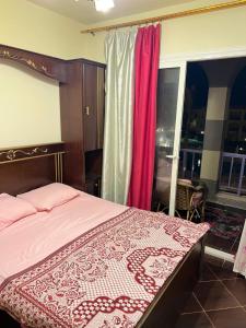 een slaapkamer met een bed met een rode en witte sprei bij Porto Matrouh Chalet X Rent family only in Marsa Matruh