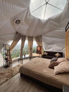 a bedroom with a large bed with a large glass ceiling at Dilijan Glamping in Dilijan