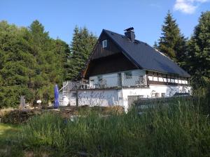 una grande casa bianca con tetto nero di Ferienhaus Anna 1 a Jindřichovice
