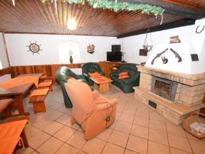 a restaurant with a fireplace and couches and tables at Chalet in Ore Mountains near Ski Slopes in Jindřichovice