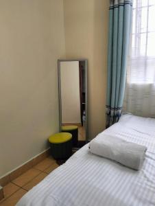 a bedroom with a large mirror and a bed at Tamara studio bedsitter, Nyanchwa Kisii in Kisii