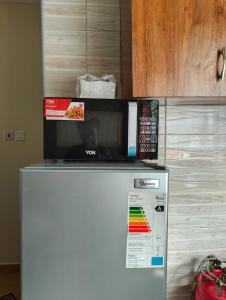 Un four micro-ondes est installé au-dessus d'un réfrigérateur. dans l'établissement Tamara studio bedsitter, Nyanchwa Kisii, à Kisii