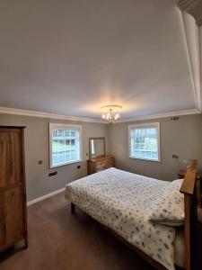 a bedroom with a bed and two windows at Tamlaught house in Glenariff
