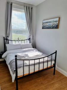 a bed in a bedroom with a window at Portrush by the Sea - 3 West Beach in Portrush