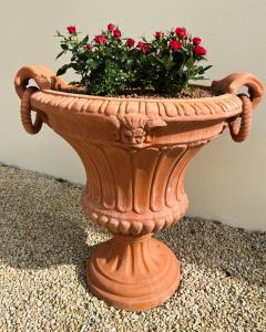 a large planter with red flowers in it at Villa du Manoir 1685 in Saint Malo