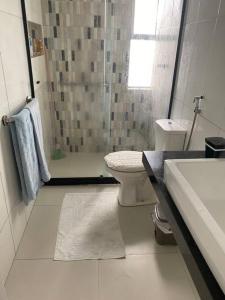 une salle de bain avec toilettes, douche et lavabo dans l'établissement Apartamento perto de tudo em condomínio fechado., à Salvador
