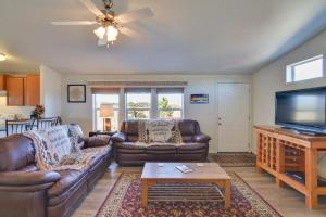 a living room with leather couches and a flat screen tv at Tranquil Cabin Getaway w/ Panoramic Mtn View! in Antero Junction