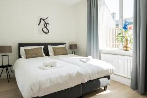 um quarto com uma grande cama branca e uma janela em 3-room's 1,5 Bath And Patio, Lovely Location em Eindhoven