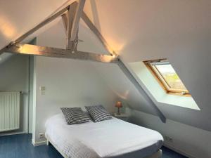 a bedroom with a bed with two pillows on it at Villa du Manoir 1685 in Saint Malo