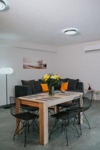 a dining room table with chairs and a couch at Pamvotis Urban Suites in Ioannina