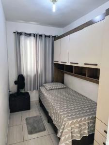 Dormitorio pequeño con cama y armarios blancos en Apartamento em Condomínio fechado., en Itatiba