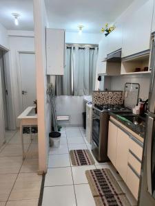 cocina con armarios blancos y fogones en Apartamento em Condomínio fechado., en Itatiba