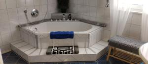 Merkendorf的住宿－ruhiger als im Hotel，浴室设有白色浴缸和蓝色毛巾