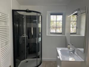 a bathroom with a glass shower and a sink at Villa du Manoir 1685 in Saint Malo