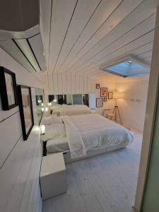 a bedroom with a large white bed with a ceiling at Duplex 90m² + terrasse in Bayonne