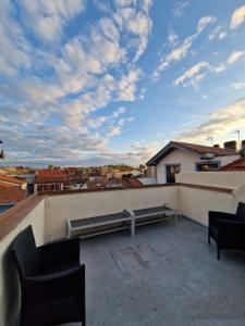 a patio with two chairs and a bench on a roof at Duplex 90m² + terrasse in Bayonne