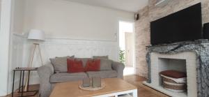 a living room with a couch and a fireplace at Villa des roses, comme à la maison in Cherbourg en Cotentin