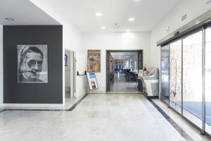 a hallway of a museum with paintings on the walls at Nautilus Hotel in Roses