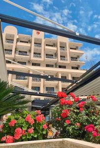 a building with red flowers in front of it at Hotel President in Shëngjin