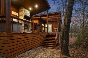 a log cabin with a staircase and a tree at Diamond Cabin w/ jet shower & secluded back deck! in Broken Bow