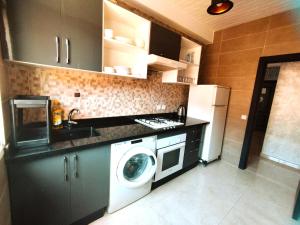 een keuken met een wasmachine en een koelkast bij cosyhomeocean in Rabat