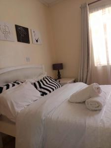 a white bed with towels on it in a bedroom at Nalelek Homes in Narok