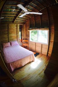 ein Schlafzimmer in einem Blockhaus mit einem Bett in der Unterkunft Mango House Toma la luna 2br in Cabarete