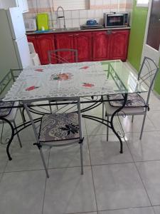 szklany stół i krzesła w kuchni w obiekcie Résidence Mathurin w mieście Anse-Bertrand