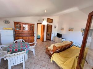 una sala de estar con dos camas y una mesa en Villa Melina Appartamenti, en Santa Maria di Castellabate