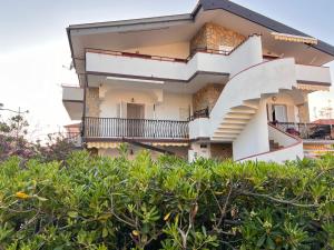 un edificio con balcones y arbustos en Villa Melina Appartamenti, en Santa Maria di Castellabate